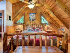 a bedroom in a log cabin with a bed at Buckhorn, 2 Bedrooms, Sleeps 6, WiFi, Jetted Tub, Fireplace, Hot Tub in Gatlinburg