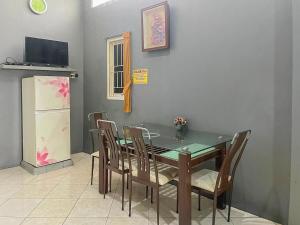 uma sala de jantar com uma mesa e cadeiras e um frigorífico em Monalisa Homestay Mitra RedDoorz em Surabaya