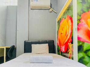 um quarto com uma cama com uma almofada e um quadro em Monalisa Homestay Mitra RedDoorz em Surabaya