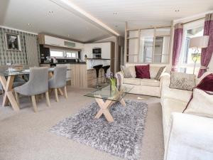 uma sala de estar com um sofá e uma mesa em Crosswinds 67 em Bembridge
