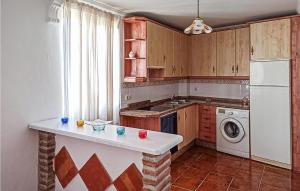 a kitchen with a white refrigerator and a washer and dryer at 4 Bedroom Gorgeous Home In Frigiliana in Nerja