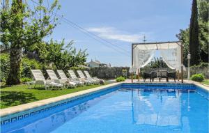 a swimming pool with chairs and a gazebo at 4 Bedroom Gorgeous Home In Frigiliana in Nerja