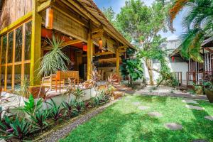 a house with a garden in front of it at Villa Pagoda, Sumptuous 4BR Villa with Tropical Vibes in Seminyak in Legian