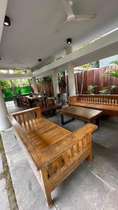 un patio con bancos y mesas de madera en un restaurante en Fu Wan Cafe Villa, en Donggang