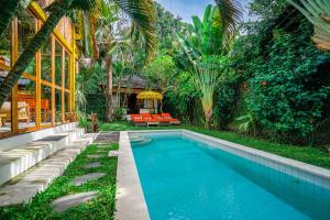 a swimming pool in the backyard of a house at Villa Pagoda, Sumptuous 4BR Villa with Tropical Vibes in Seminyak in Legian