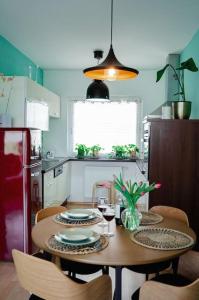 a kitchen with a table with plates and glasses of wine at Boho-Chic-Wohnung Neusiedl in Neusiedl am See