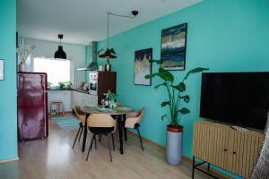 a living room with a table with chairs and a tv at Boho-Chic-Wohnung Neusiedl in Neusiedl am See