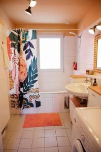 a bathroom with a sink and a tub and a window at Boho-Chic-Wohnung Neusiedl in Neusiedl am See