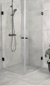 La salle de bains est pourvue d'une douche avec une porte en verre. dans l'établissement Centrum lägenhet, à Skövde