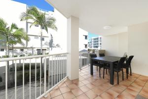 a dining room with a table and chairs on a balcony at Lindomare Apartments in Caloundra