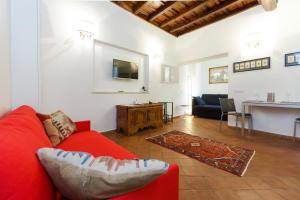 a living room with a red couch and a table at NAVONA, Old Rome Lodge in Rome