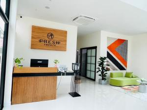 an office with a reception desk and a green chair at Fresh Resort Pattaya in Ban Huai Yai