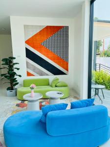 a living room with a blue couch and a painting at Fresh Resort Pattaya in Ban Huai Yai