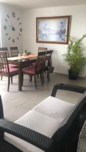 comedor con mesa, sillas y reloj en Casa Lucy, en Ibagué