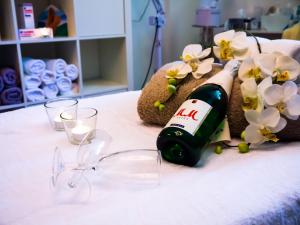 una botella de vino y copas en una cama con flores en Vital-Hotel Erika, en Bad Kissingen