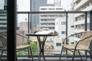 a table and chairs on a balcony with a view at Tokyo IKOI HOTELー綺麗なホテル in Tokyo