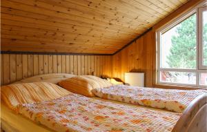 エクスタータールにあるNice Home In Extertal With 3 Bedrooms, Sauna And Wifiのウッドウォールと窓が備わるドミトリールームのベッド2台分です。