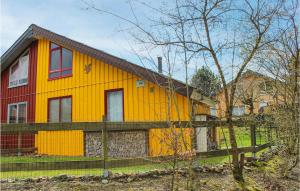 een geel en rood huis met een hek bij 3 Bedroom Awesome Home In Extertal in Extertal
