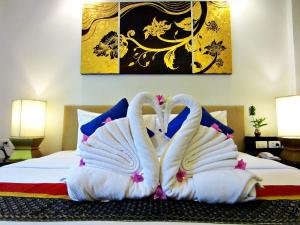 Twee witte zwanen zitten op een bed. bij Yantarasri Resort in Chiang Mai