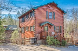 una casa in legno con una recinzione di fronte ad essa di Standing Bear Lodge, 5 Bedrooms, Sleeps 18, Pool Table, Air Hockey, Hot Tub a Gatlinburg