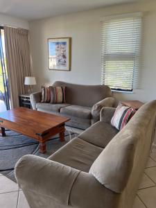 a living room with two couches and a coffee table at Kings Row Apartments in Caloundra