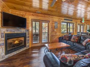 a living room with a fireplace and a tv at Family Ties Lodge in Gatlinburg