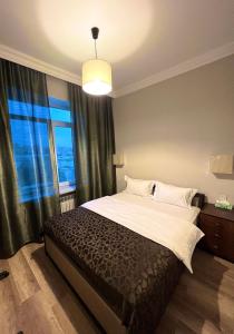 a bedroom with a large bed with a large window at SHAH INN Panoramic Apartments Old City F1 Track Принимаем карты МИР in Baku
