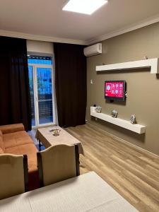 a living room with a couch and a tv on a wall at SHAH INN Panoramic Apartments Old City F1 Track Принимаем карты МИР in Baku