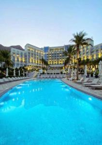 una gran piscina azul frente a un complejo en Ocean View Address Beach Resort Fujairah فندق و منتجع شاطئ العنوان الفجيره, en Sharm