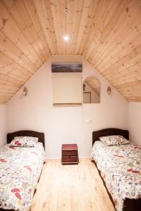 two beds in a room with wooden ceilings at Pullijärve Holiday Park in Misso