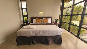 a bedroom with a large bed and large windows at Hotel Mirador in Baguio