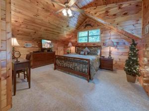 1 dormitorio con 1 cama en una cabaña de madera en Our Mountain Getaway, 3 Bedrooms, Sleeps 12, Hot Tub, 2 Jacuzzis, WiFi, en Sevierville