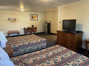 a hotel room with two beds and a flat screen tv at Holiday Motel Oakdale in Oakdale