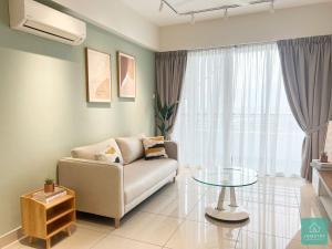 a living room with a couch and a glass table at JOMSTAY Majestic Ipoh Suites in Ipoh