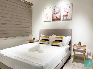 una camera da letto con letto, lenzuola e cuscini bianchi di JOMSTAY Majestic Ipoh Suites a Ipoh