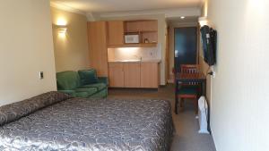 a hotel room with a bed and a living room at 97 Motel Moray in Dunedin