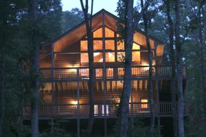 una gran casa de madera en medio de árboles en Our Mountain Getaway, 3 Bedrooms, Sleeps 12, Hot Tub, 2 Jacuzzis, WiFi en Sevierville