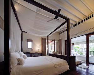 a bedroom with a large bed with a canopy at SALA Samui Choengmon Beach Resort in Choeng Mon Beach