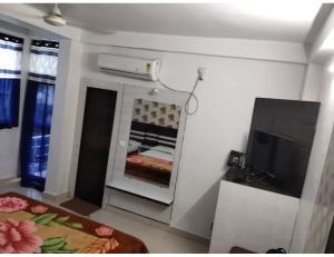 a room with a bed and a tv in a room at Hotel Agrawal, Pachmarhi in Pachmarhī