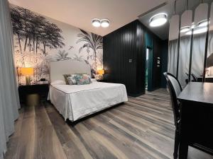 una camera con letto e un dipinto di palme di Al Boschetto a Castel Volturno