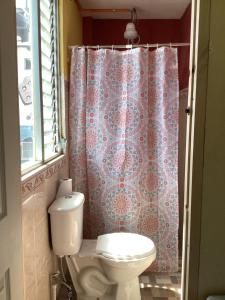 a bathroom with a toilet and a shower curtain at CASA BATZ #1 in San Pedro La Laguna