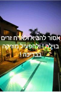 une photo d'une piscine la nuit dans l'établissement Thai villa eilat - וילה תאי אילת, à Eilat