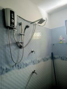 eine Dusche im Bad mit einer gefliesten Wand in der Unterkunft Ashi Galle Villa in Galle