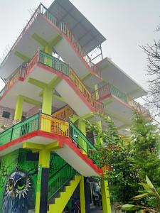 un bâtiment avec des escaliers colorés et un hibou peint sur lui dans l'établissement Parbati Headquarters, à Kasol