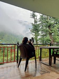 a woman sitting in a chair with a baby at Parbati Headquarters in Kasol