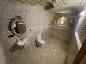 a bathroom with a sink and a toilet and a mirror at DEDE CAVE KONAk in Urgup