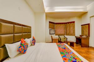 a bedroom with a large bed and a desk at FabHotel Shimla Resort in Lucknow