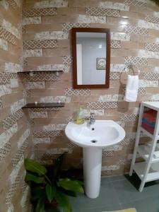 La salle de bains est pourvue d'un lavabo et d'un miroir. dans l'établissement Seaview Hill (Family room with private Pool), 