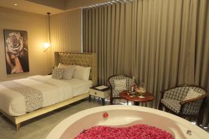 a bedroom with a bed and a bath tub at Apricot Motera in Ahmedabad