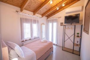 a bedroom with a bed and a flat screen tv at The Archanes Sapphire in Archanes